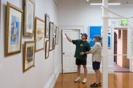 Two men looking at artworks in a gallery