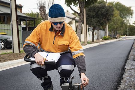 Man in fluro with notepad and equipment