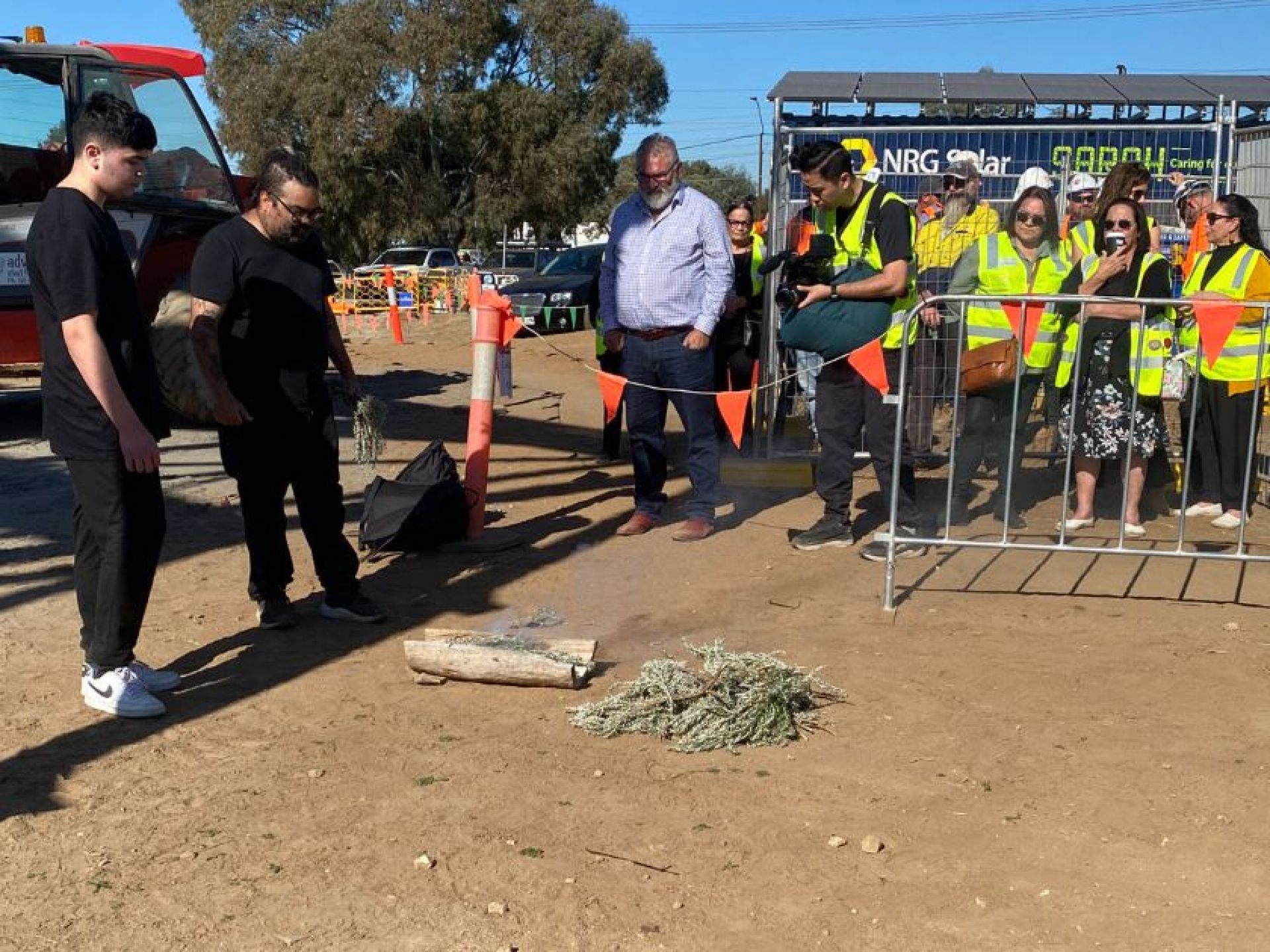 Group of people watching a smoking ceremony on a construction site