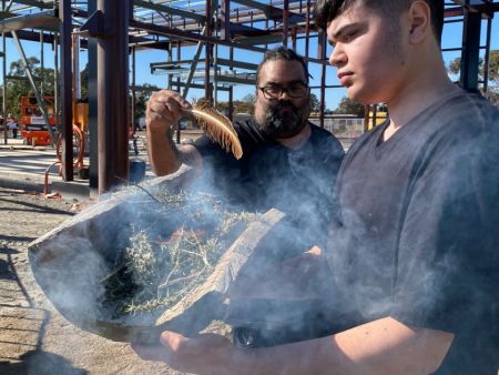 Two Aboriginal men performing a smoking ceremony