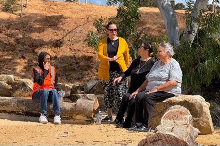 First Nations women sitting on rocks