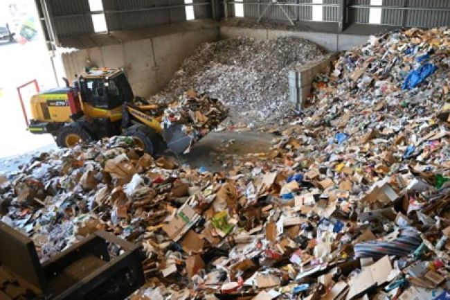 A truck grabbing rubbish in a recycling centre