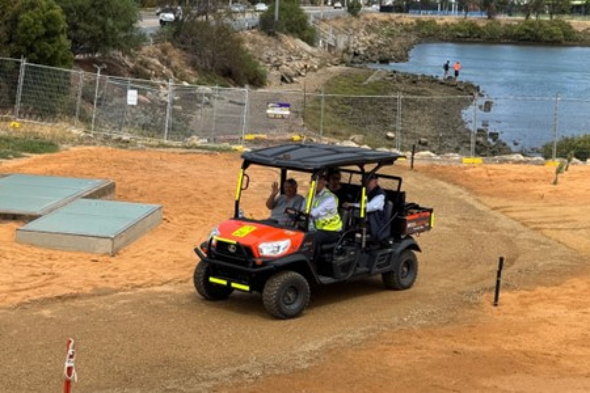People in a car driving on site