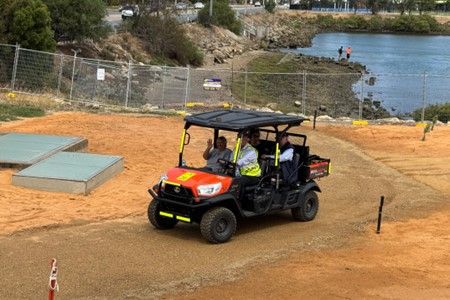 People in a car driving on site