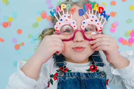 Child with Happy Birthday glasses